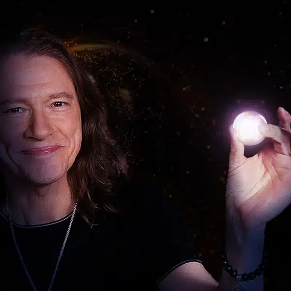 Robben Ford holding a small ball in left hand that emits magical pink light